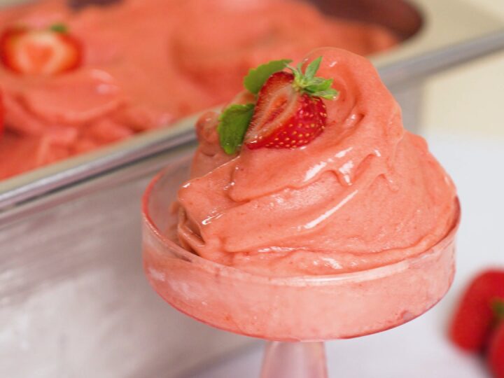 Eine Portion Erdbeereis mit frischen Erdbeeren