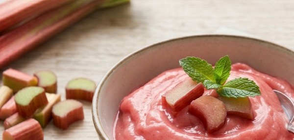 Eine Schale Rhabarber-Sorbet neben etwas frischem Rhabarber